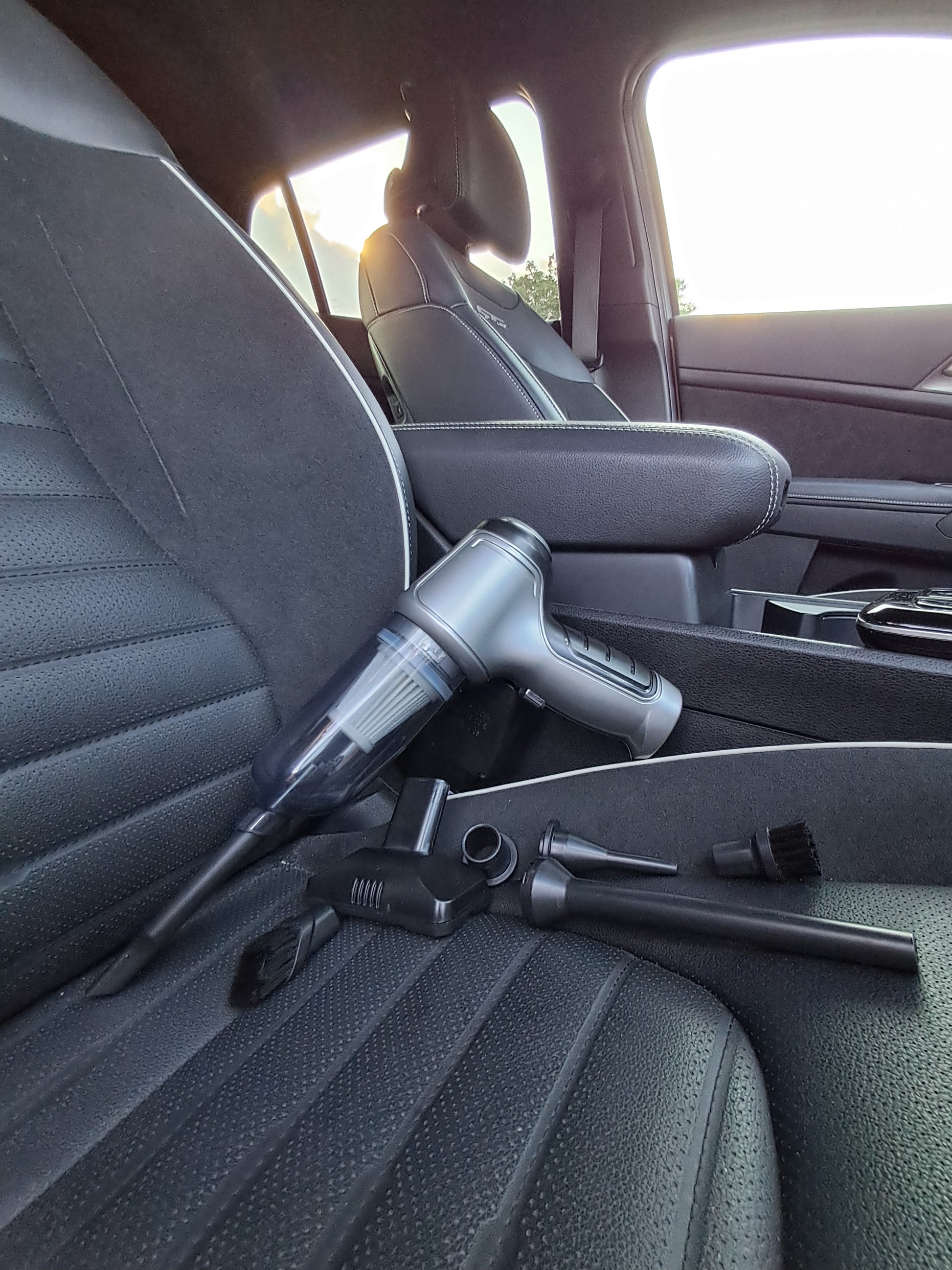 Car interior with a vacuum cleaner on the back seat